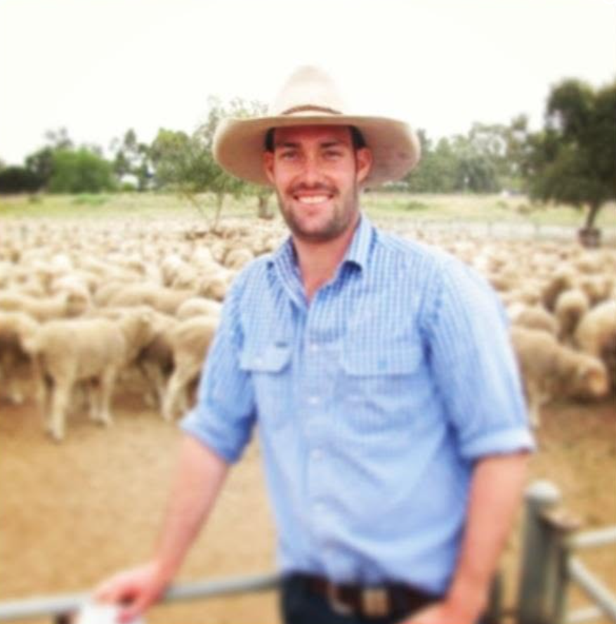 Tom Boyle standing beside sheep on the farm